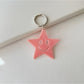 Silver star keychain displayed alongside other metallic accessories