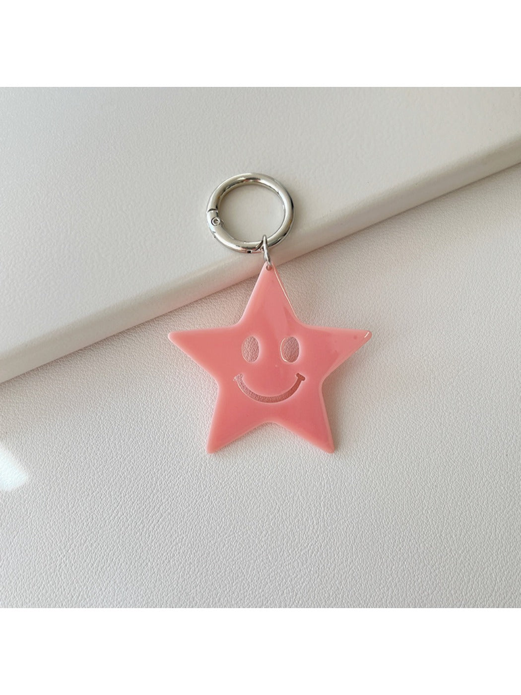 Silver star keychain displayed alongside other metallic accessories