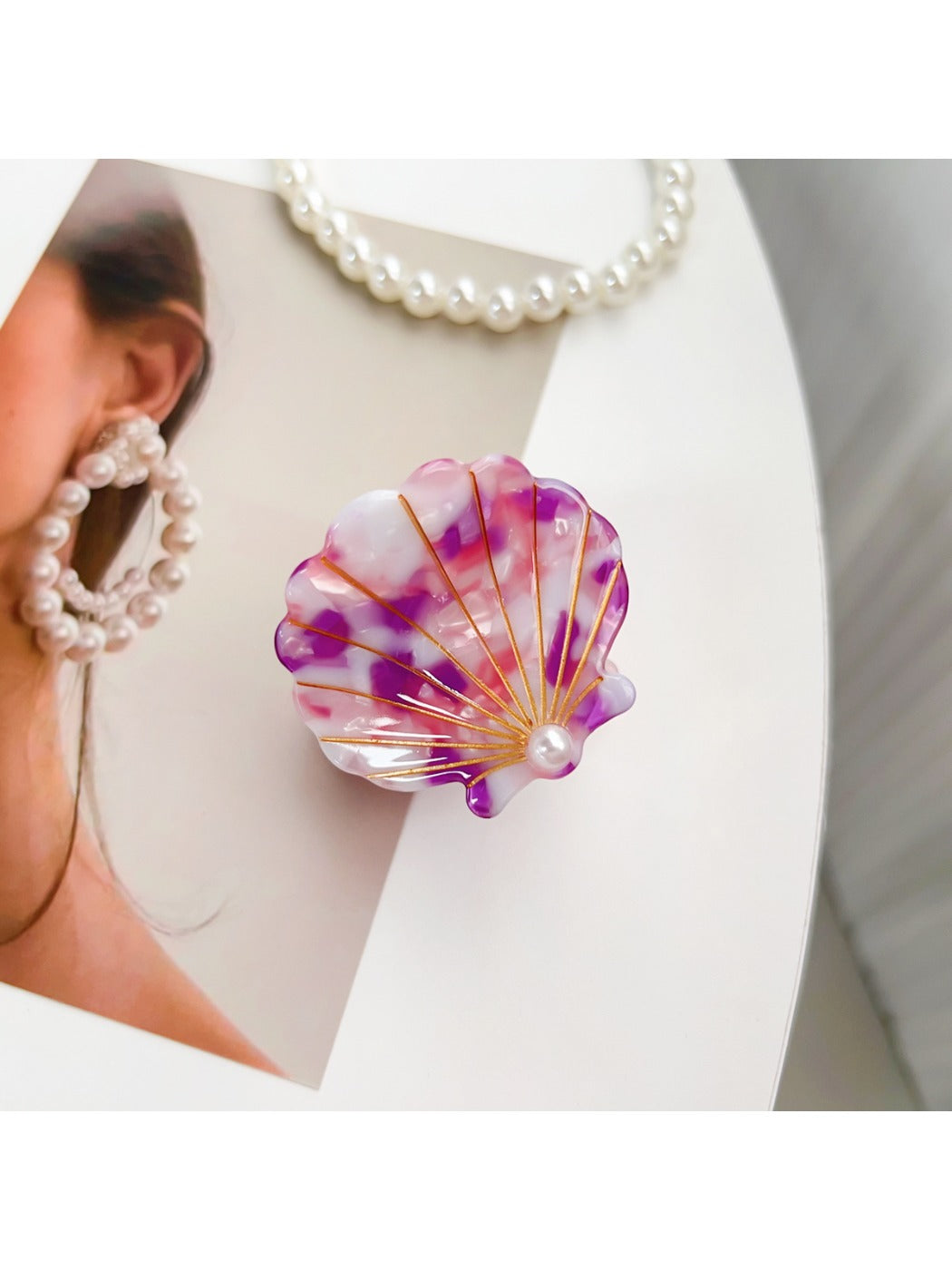 Beau hair claw clip next to seashells for decorative display
