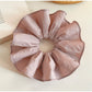 Soft pink scrunchie displayed on a wooden surface with natural lighting
