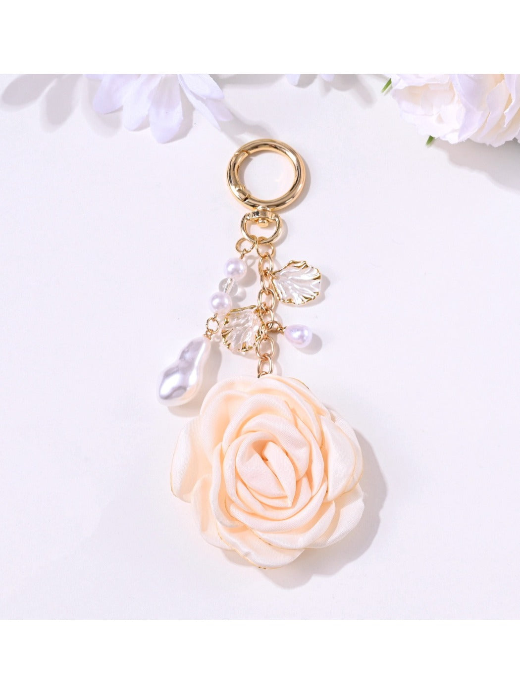 Rose pendant keychain hanging from a bag strap, highlighting its compact size