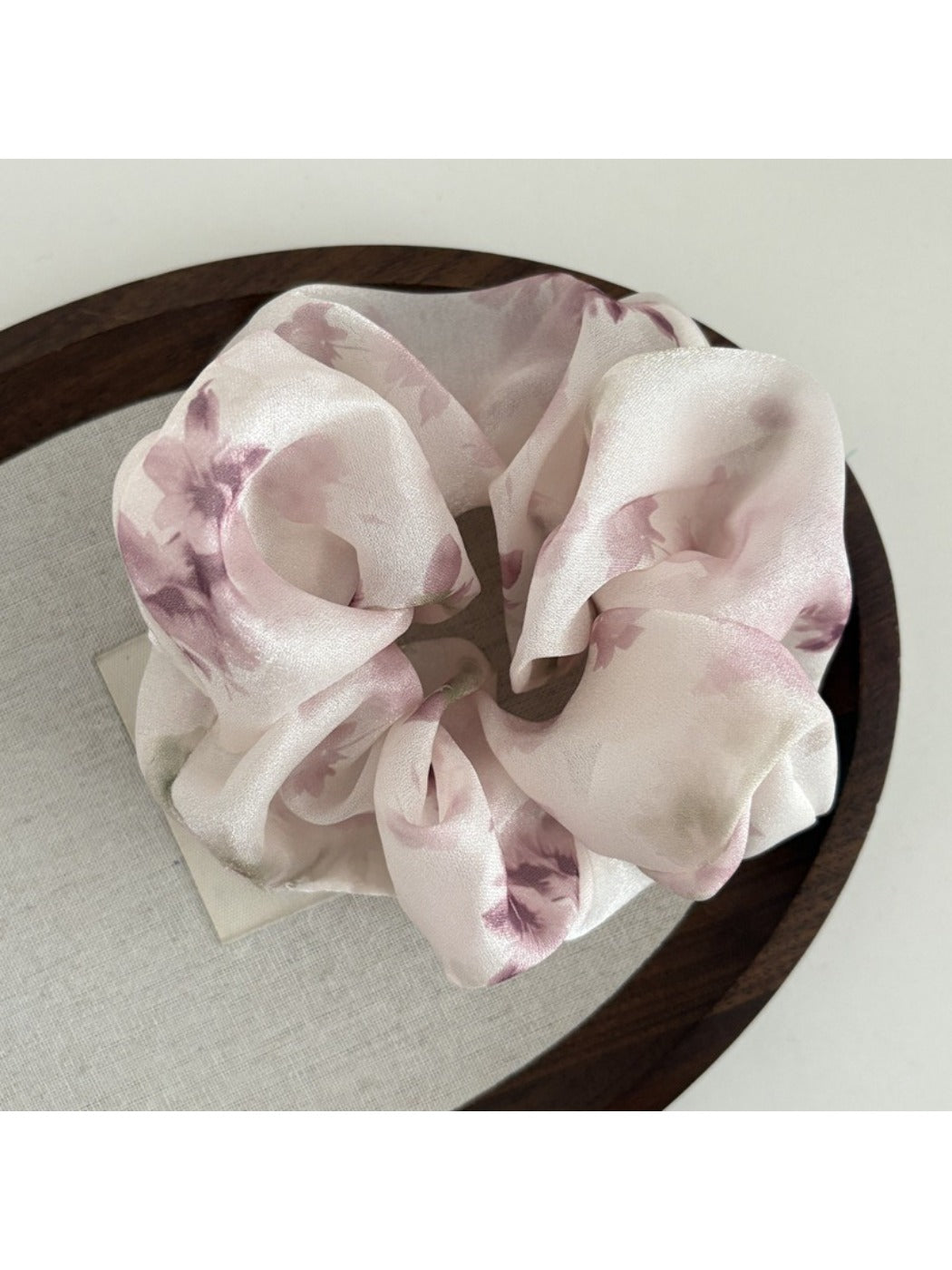 Gifty satin scrunchie wrapped around wrist as a stylish accessory