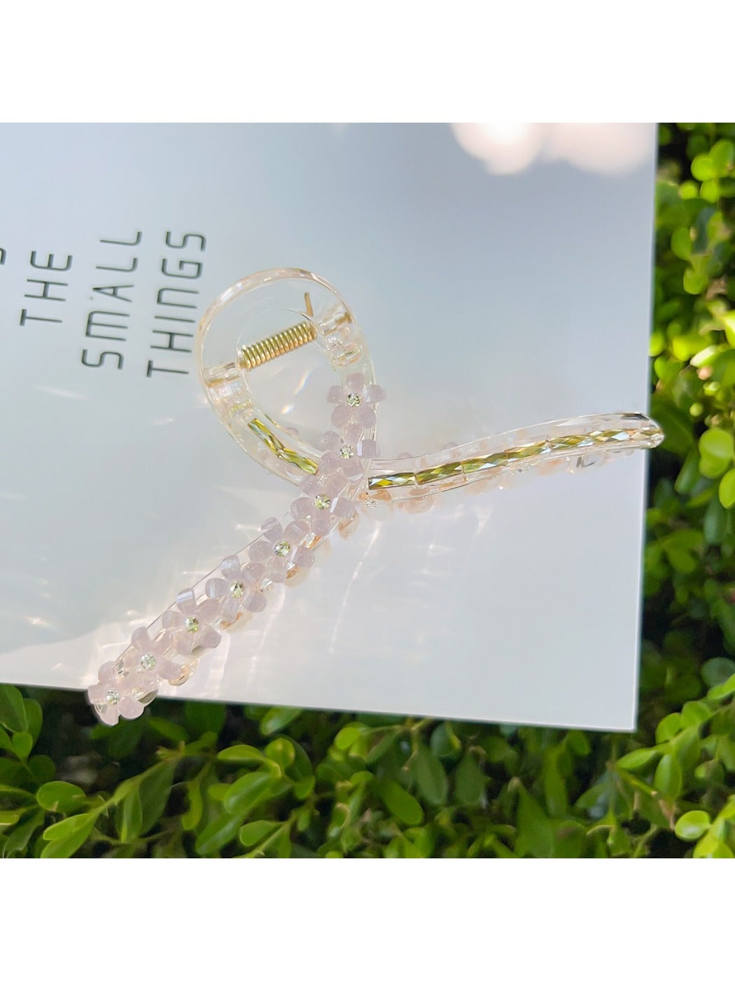 Beau flower crisscross hair claw clip on model's hair from back