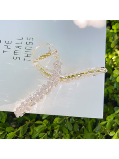 Beau flower crisscross hair claw clip on model's hair from back