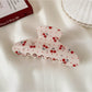 Beau printed half moon hair claw clip on neutral surface with natural lighting