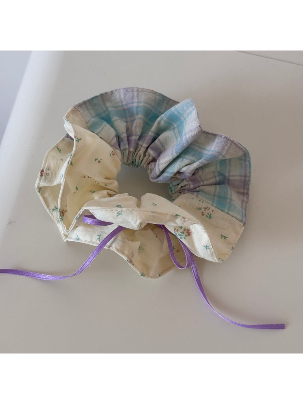 Gifty checkered bow ribbon scrunchie on a wooden surface