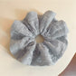 Gifty solid color ruffled scrunchie in soft fabric, styled on a white background