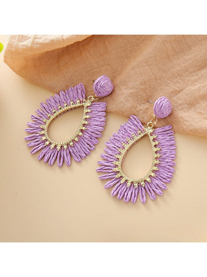 Earedge raffia teardrop hollow earrings placed next to green leaves