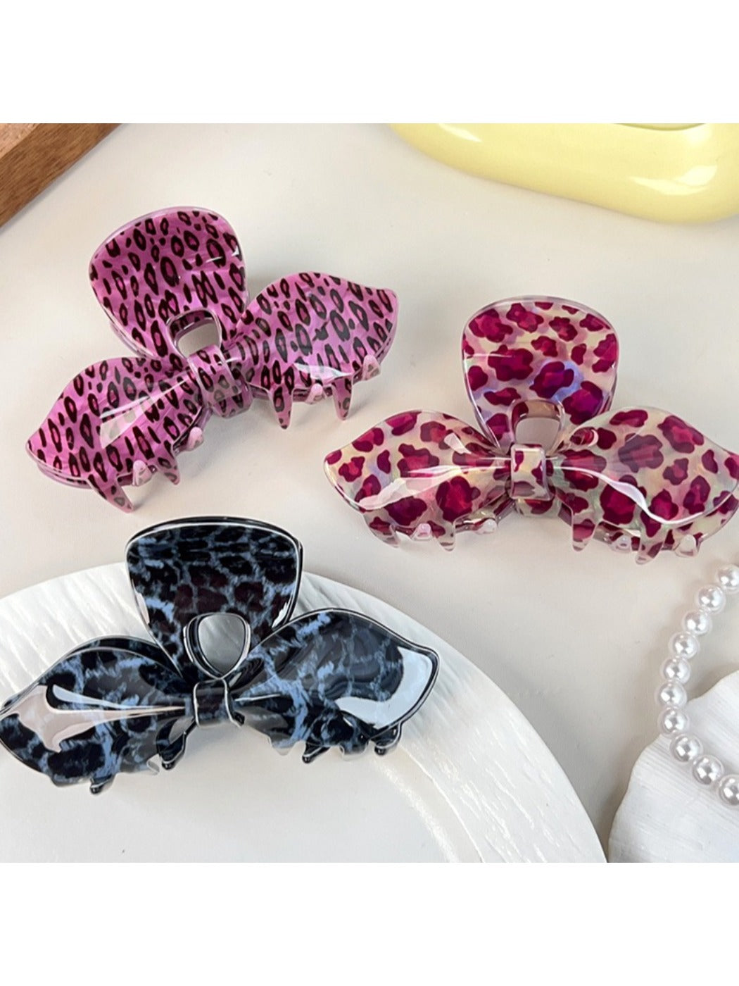 Side view of Beau bow-shaped claw clip with leopard print design
