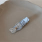 Beau sparkling bow hair clip held in hand highlighting its size and sparkle