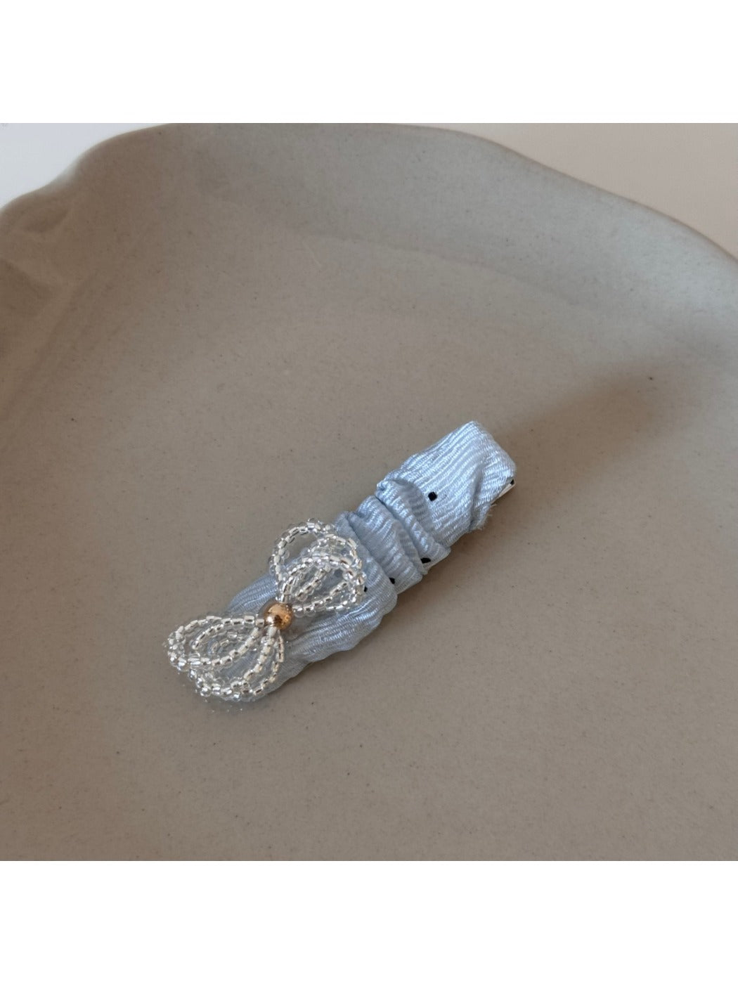 Beau sparkling bow hair clip held in hand highlighting its size and sparkle