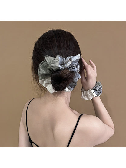 Close-up of Gifty scrunchie showing patchwork plaid fabric details