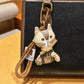 Vintage cat charm keychain hanging from a bag zipper pull