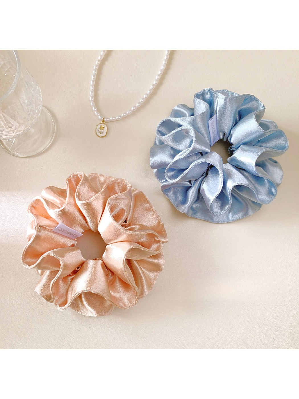 Gifty satin double layer scrunchie in deep burgundy displayed on a wooden surface