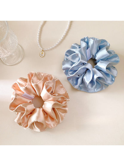 Gifty satin double layer scrunchie in deep burgundy displayed on a wooden surface