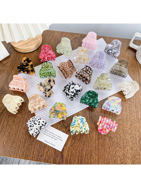 Small colorful crescent-shaped claw clip with vibrant multicolor pattern