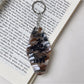 Close-up of metal keyring and colorful diamond pendant with geometric design