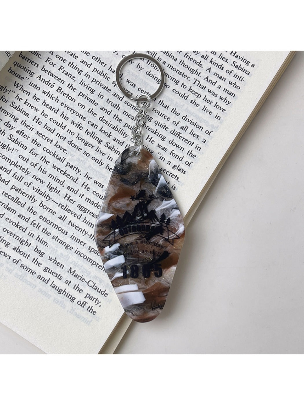 Close-up of metal keyring and colorful diamond pendant with geometric design