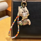 Multiple vintage cat charm keychains arranged in a row on a dark surface