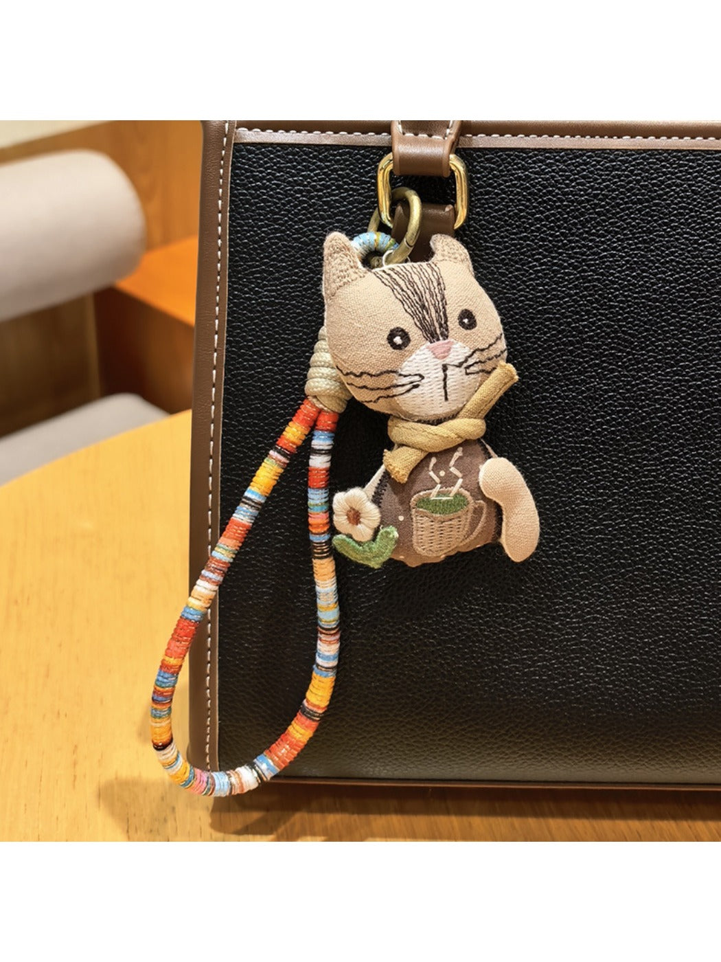 Multiple vintage cat charm keychains arranged in a row on a dark surface