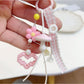 Side view of pink mushroom keychain highlighting its curved cap and attached keyring