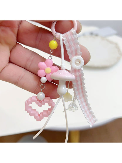 Side view of pink mushroom keychain highlighting its curved cap and attached keyring