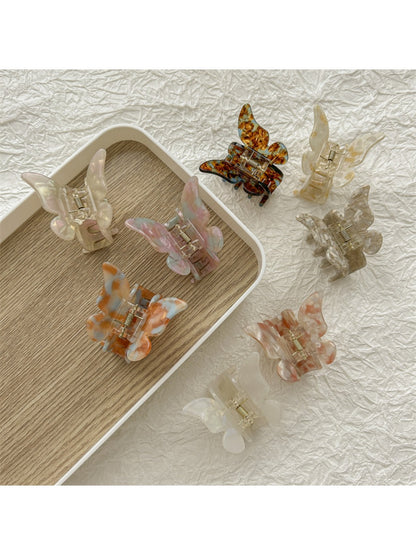 Close-up of Beau butterfly claw clip showing light pastel colors and wing details