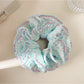 Blue ruffle scrunchie worn on a wrist as a fashion accessory
