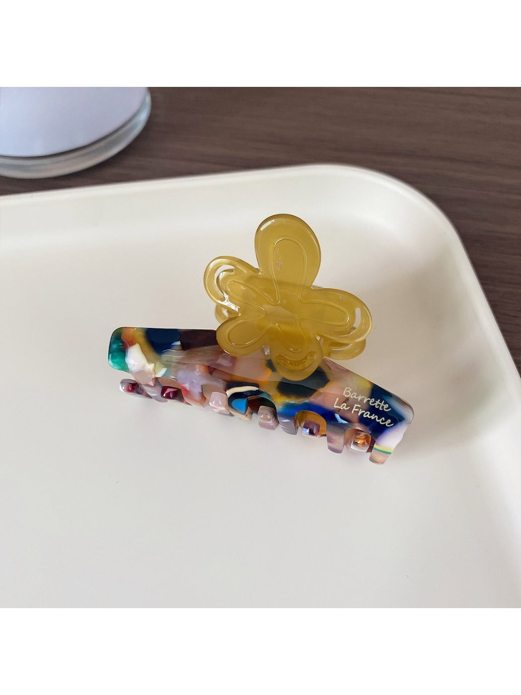 Beau Half Moon Flower Hair Claw Clip next to matching floral accessories on a table