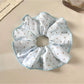 Gifty polka dot scrunchie displayed on a wooden surface