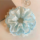 Blue lace scrunchie displayed on a white background showing texture