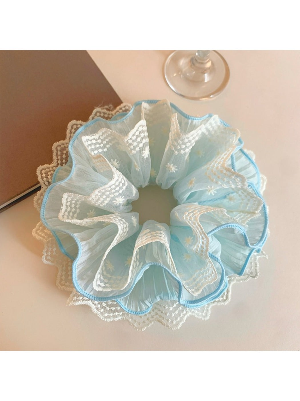 Blue lace scrunchie displayed on a white background showing texture