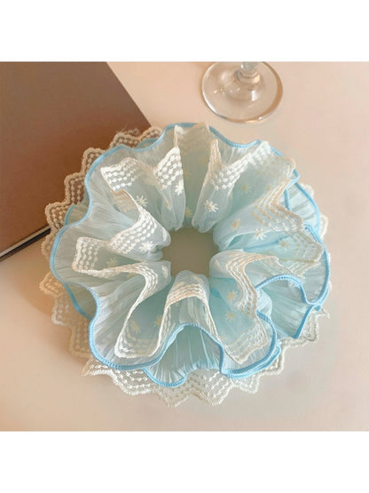 Blue lace scrunchie displayed on a white background showing texture