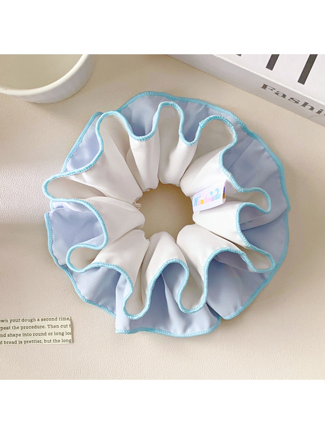Blue double layer scrunchie wrapped around a ponytail