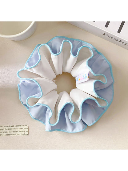 Blue double layer scrunchie wrapped around a ponytail