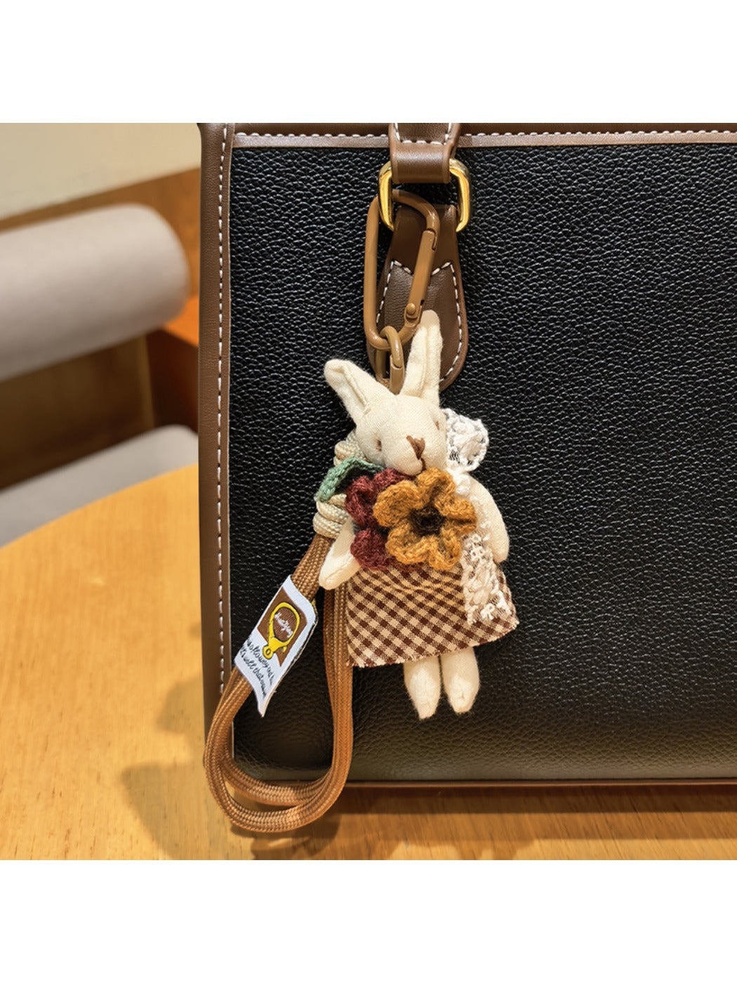 Rabbit charm keychain displayed on a fabric surface with soft lighting