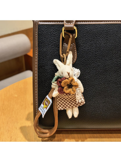 Rabbit charm keychain displayed on a fabric surface with soft lighting