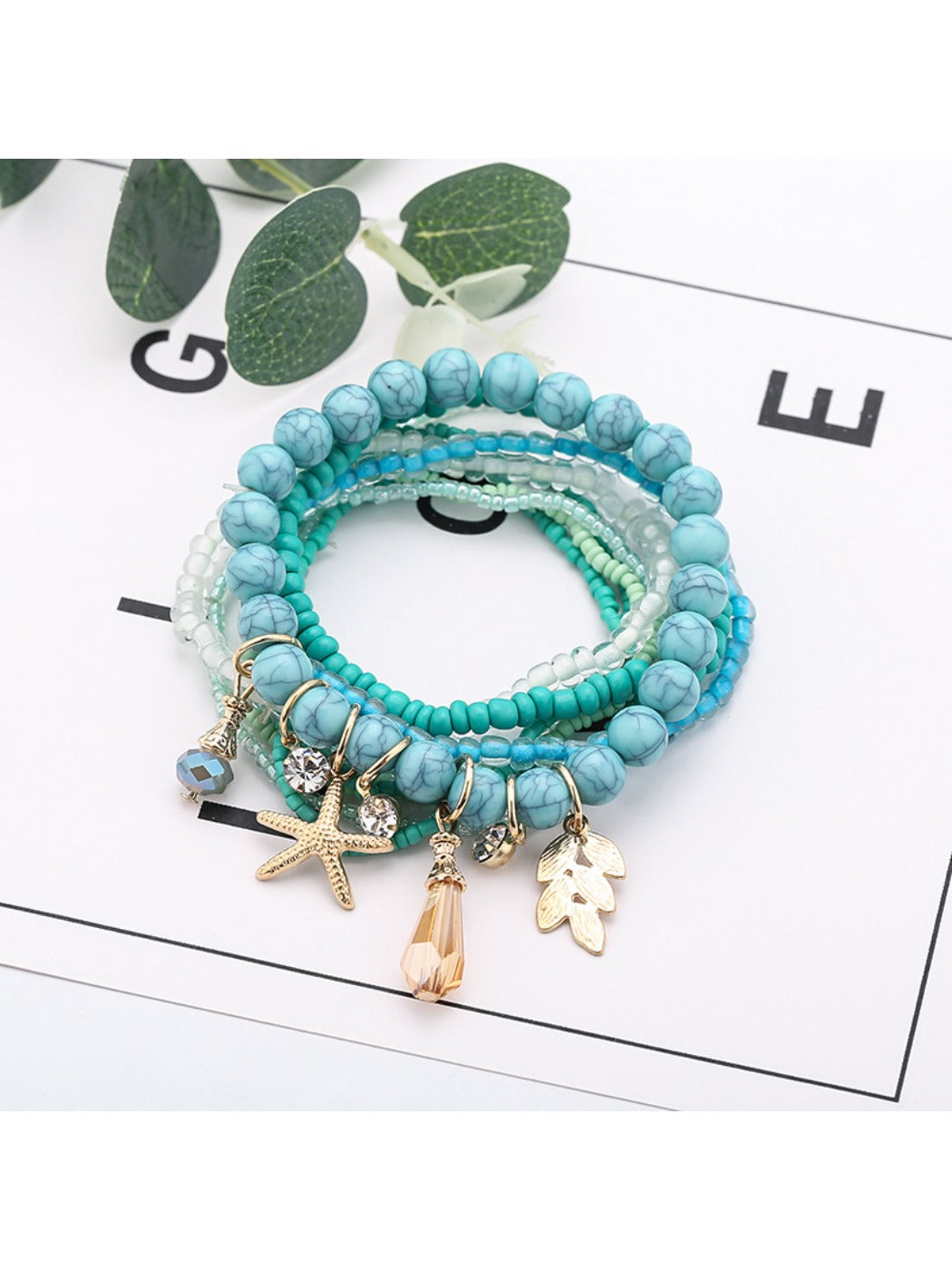 Lovra stackable bracelet with ocean charm displayed on a wooden surface