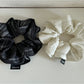 Side view of vintage pleated fabric scrunchie highlighting fabric folds