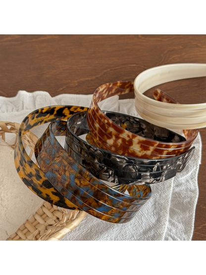 Model adjusting Gifty wide geometric fashion headband in mirror