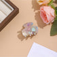 Beau vibrant acetate hair clip resting on a neutral fabric surface
