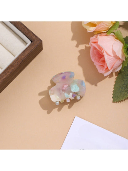 Beau vibrant acetate hair clip resting on a neutral fabric surface