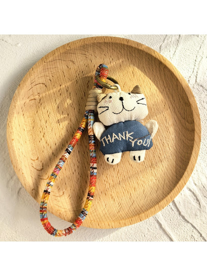 Keypus cartoon doll keychain with smiling face and red outfit close-up