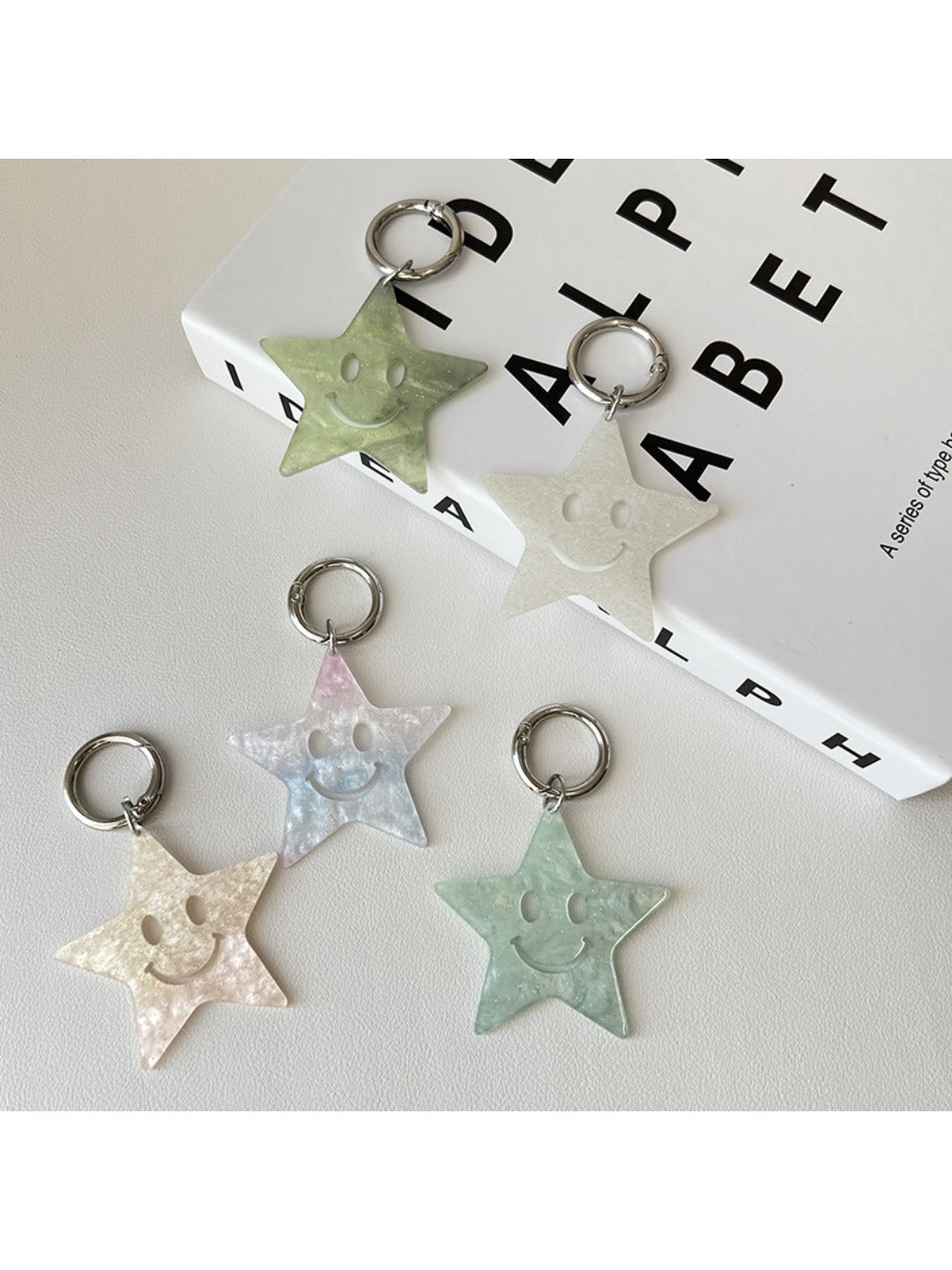 Silver star pendant keychain attached to a set of keys on a wooden surface