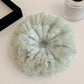 Side view of mint green plaid tulle ruffle scrunchie showing texture and pattern