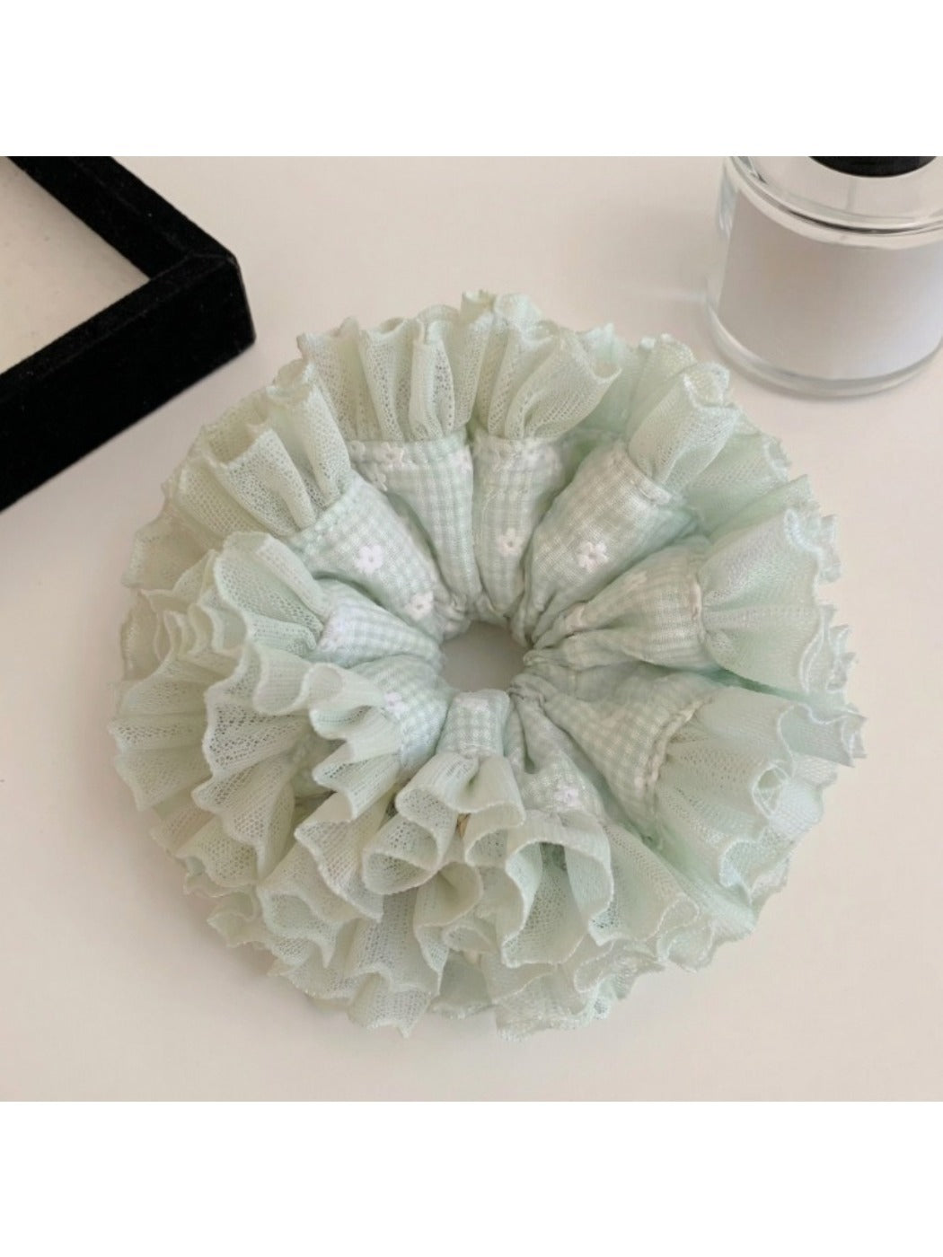 Side view of mint green plaid tulle ruffle scrunchie showing texture and pattern
