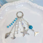 Close-up of ocean themed pendant keychain showing wave design and silver key ring
