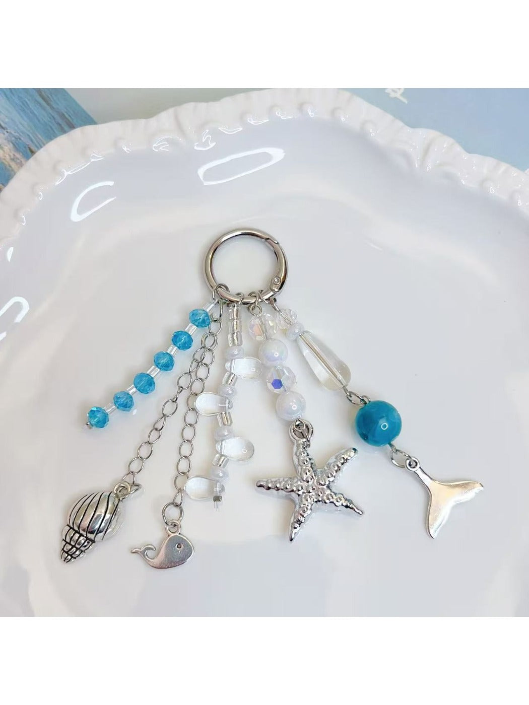 Close-up of ocean themed pendant keychain showing wave design and silver key ring