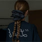 Gifty scrunchie wrapped around a ponytail on a model with brown hair