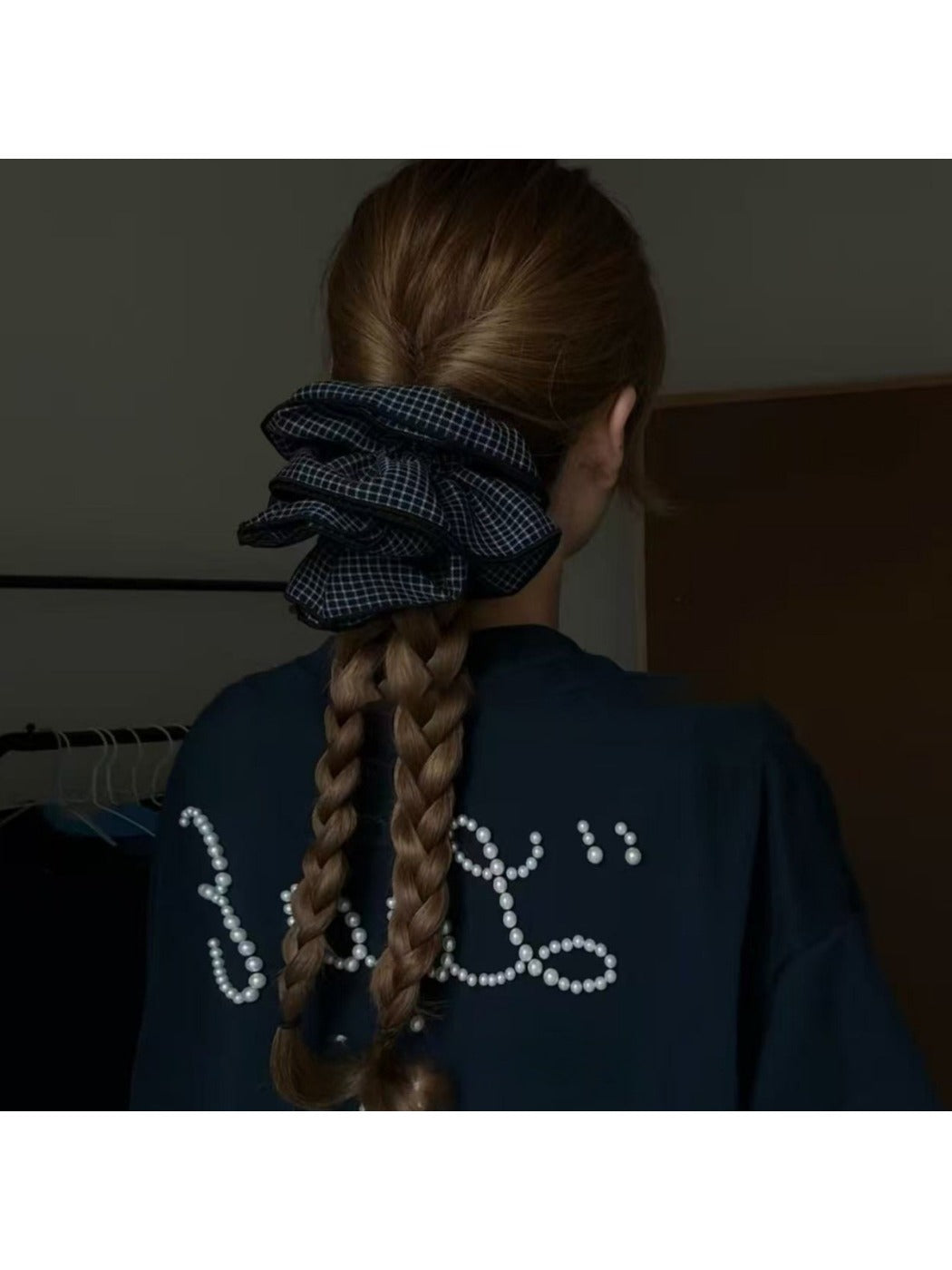 Gifty scrunchie wrapped around a ponytail on a model with brown hair